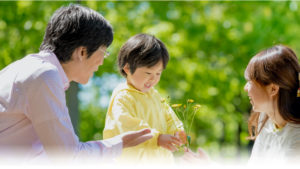 子供が両親にお花を渡す様子